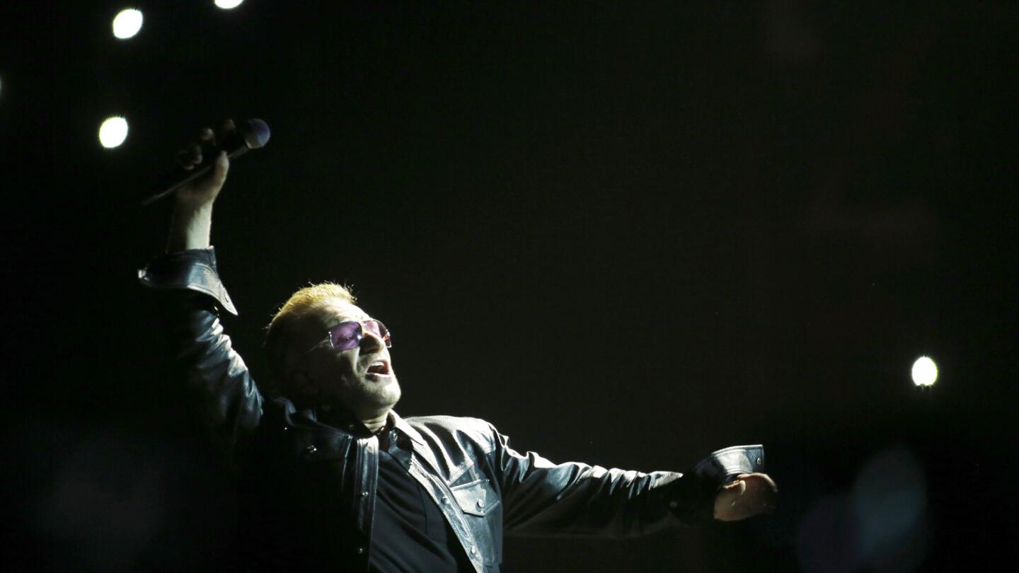 U2 lead singer Bono, greeting the audience at the opening of the Forum show, looks none the worse for wear after a 2014 bicycle accident in which he suffered broken bones.