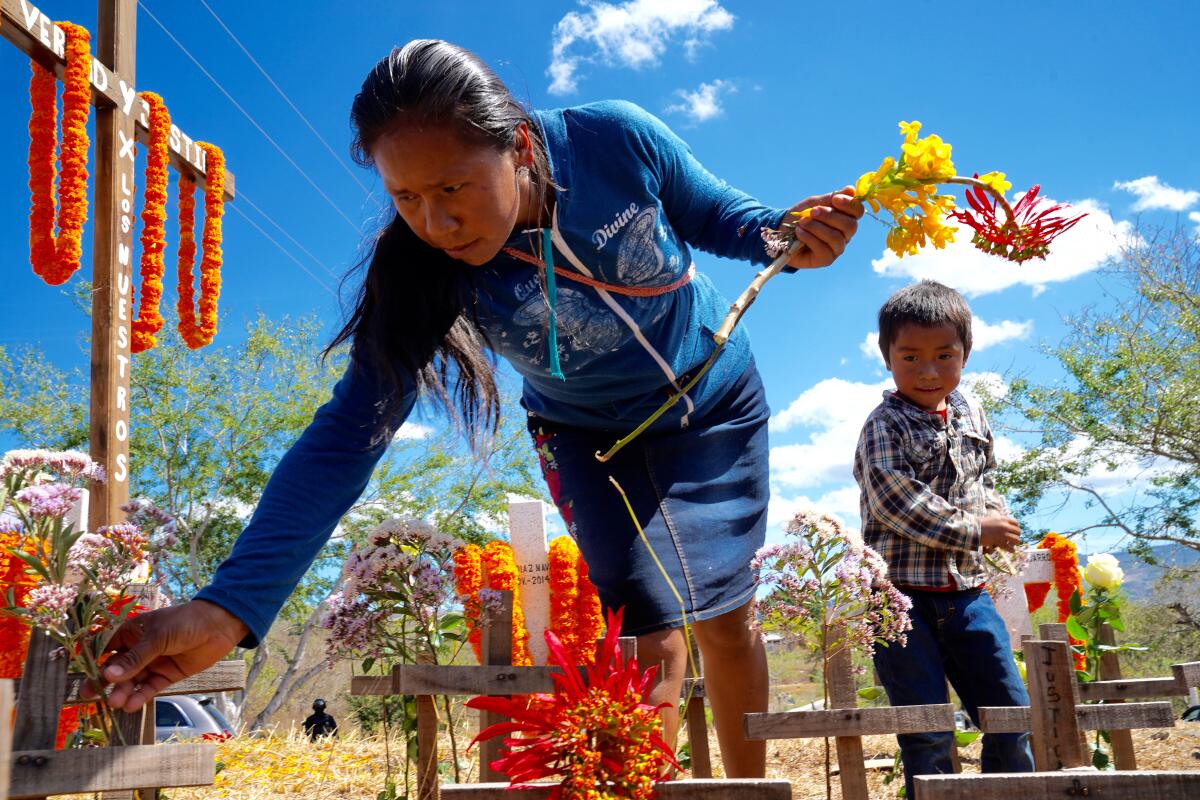 Rosalina Azacualpan Calvario, 25, and her son lay flowers at a memorial for the disappeared on Feb. 8 in Chilapa de Alvarez.