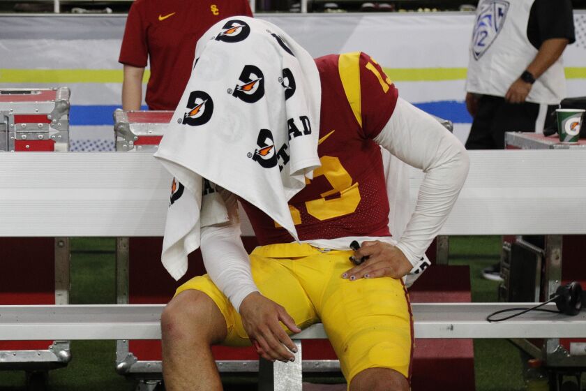 LAS VEGAS, NV - DECEMBER 2, 2022: USC Trojans quarterback Caleb Williams (13) sits under a towel on the bench.