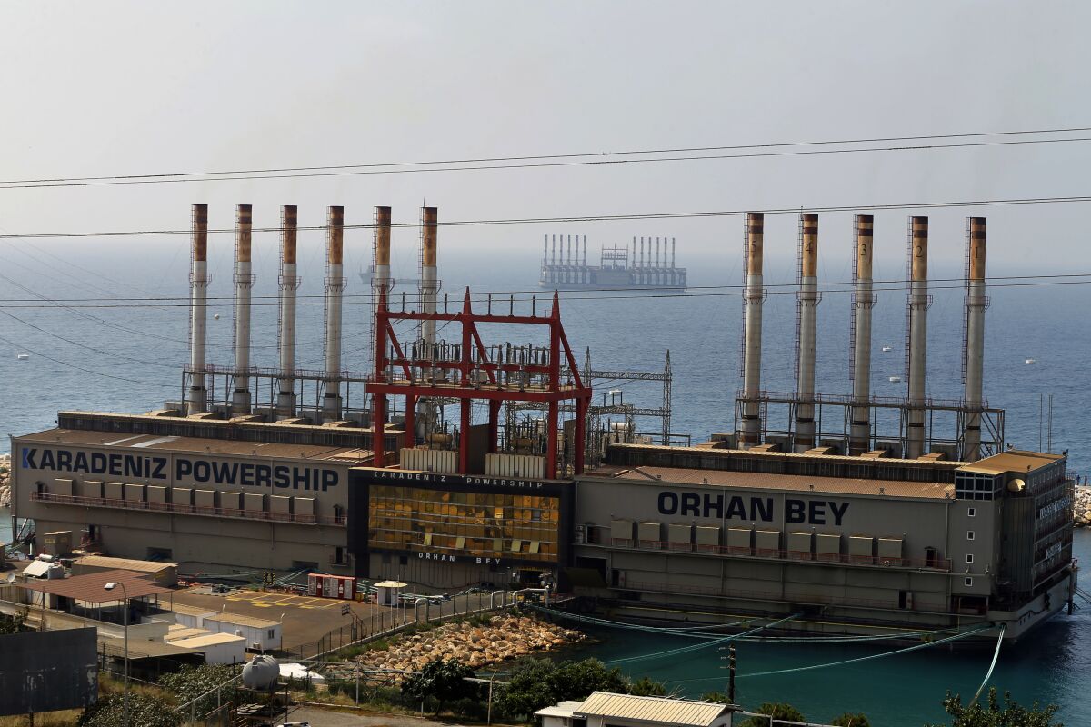 FILE - In this July 16, 2018 file photo, shows the Karadeniz Powership Orhan Bey, foreground, and a second floating power station off the coast at Jiyeh, south of Beirut, Lebanon. The Turkish company, Karpowership, supplying electricity to Lebanon from two power barges off the coast of Beirut said Friday, Oct. 1, 2021, it has halted supplies after its contract with the Lebanese state electricity company expired. (AP Photo/Bilal Hussein, File)