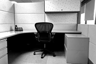 Depicting empty office cubicles with chairs, desks and metal cabinets.