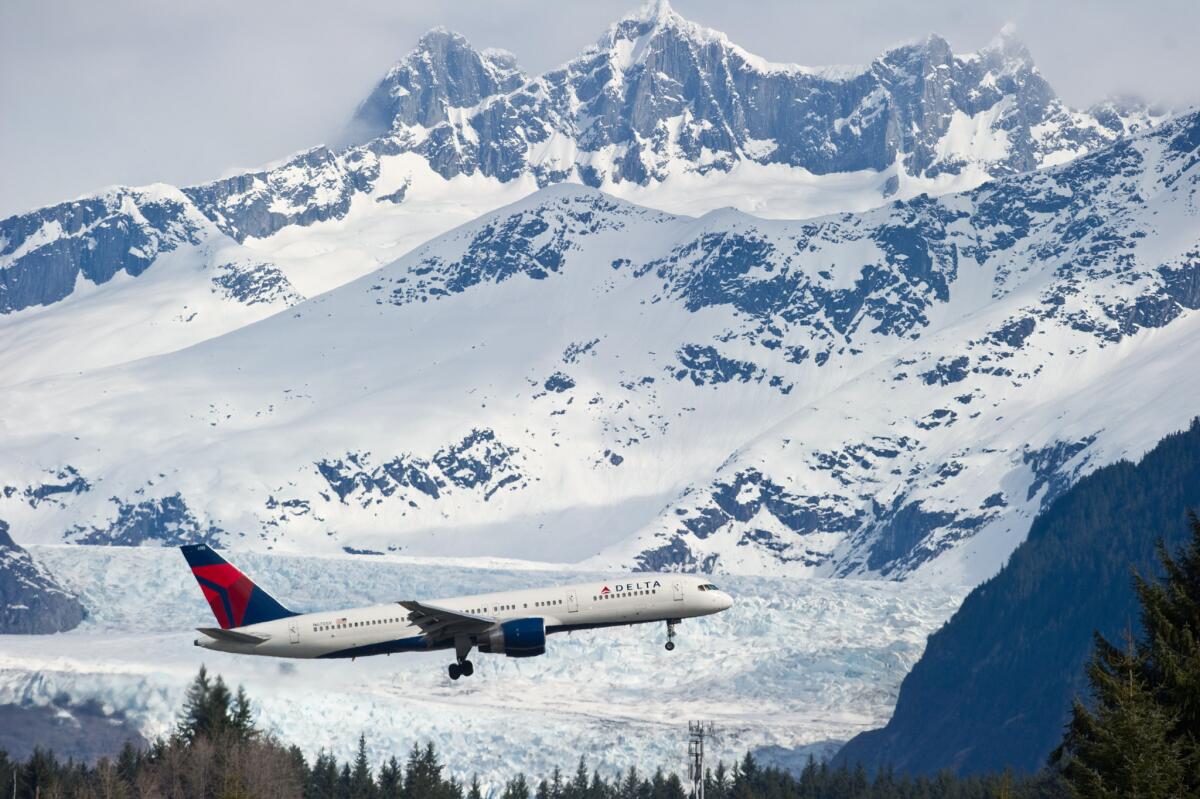 A Delta Air Lines plane flies over Juneau International Airport in Juneau, Alaska. Delta announced that passengers can use electronic devices from takeoff to landing on international flights as well as domestic ones.