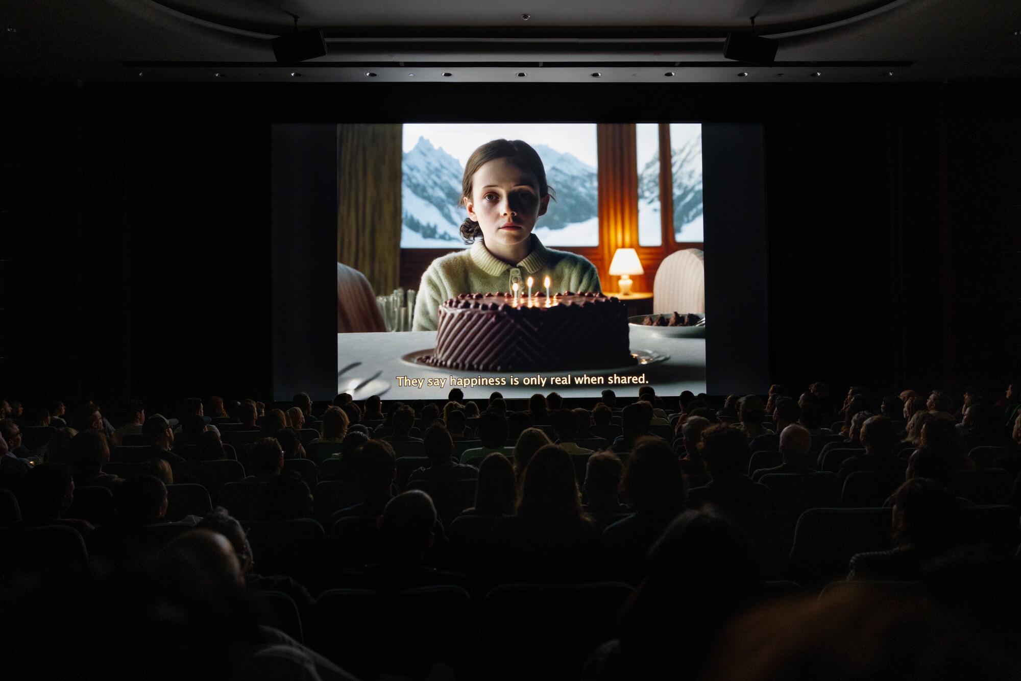 A still image from a film showing a girl in front of a birthday cake