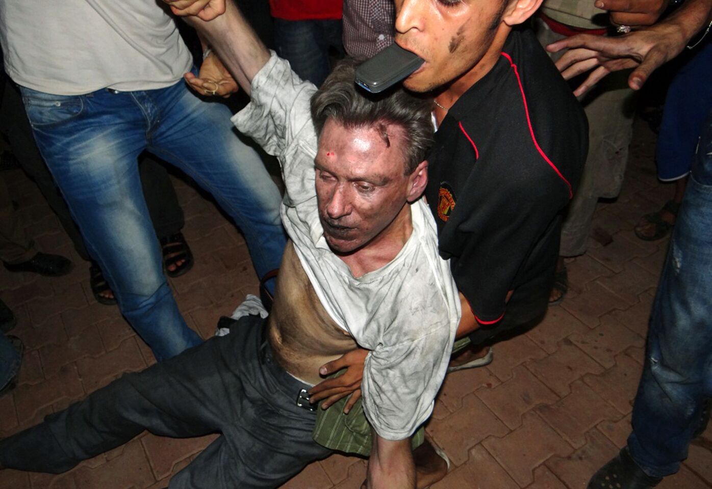 Libyan civilians help an injured man, identified by eyewitnesses as U.S. Ambassador to Libya J. Christopher Stevens, at the U.S. consulate compound in Benghazi.