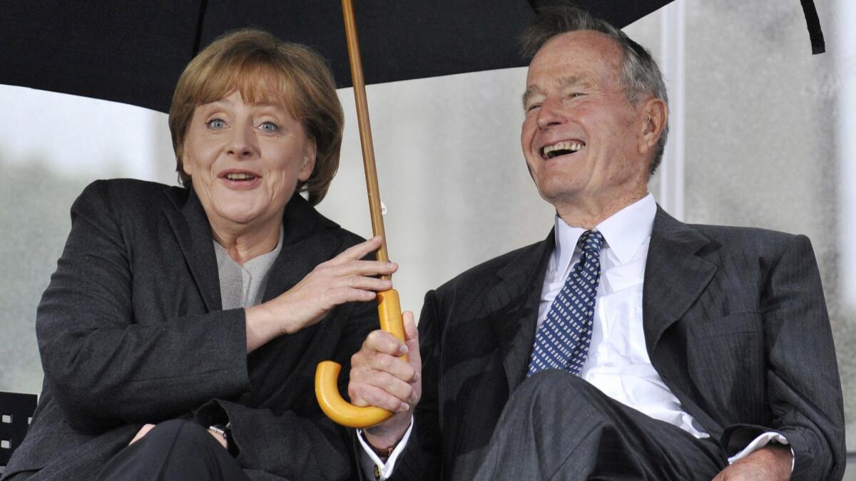 Former President George H.W. Bush and German Chancellor Angela Merkel attend a ceremony to inaugurate the new U.S. Embassy building in Berlin.