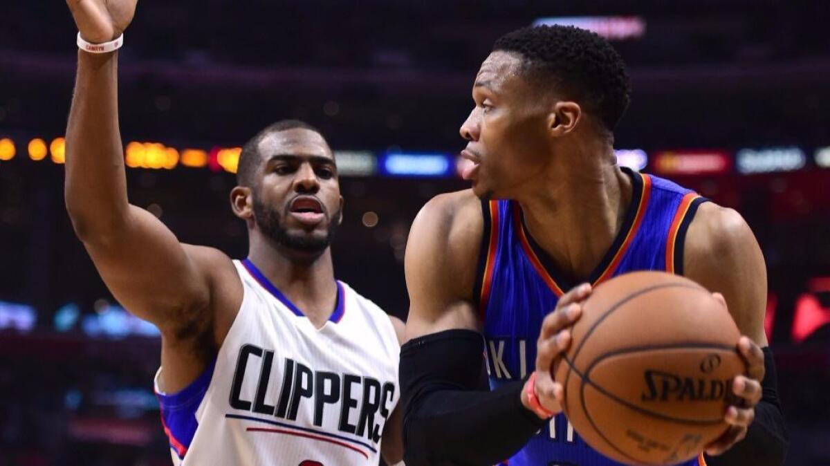 Clippers guard Chris Paul defends Oklahoma City Thunder guard Russell Westbrook on Monday night at Staples Center. Paul would leave the game after his thumb was injured in a collision involving Westbrook.