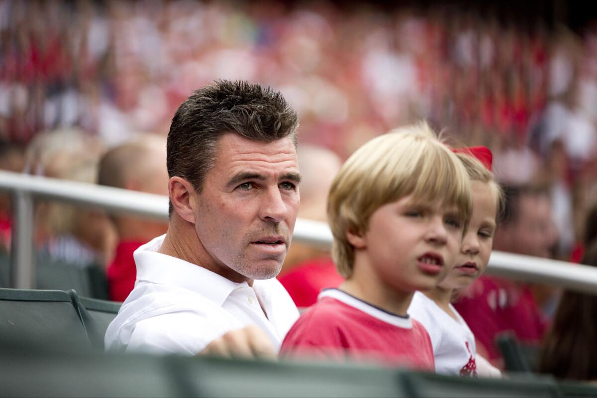 Jim Edmonds sits with his family during a game between the St. Louis Cardinals and the Pittsburgh Pirates in 2012.
