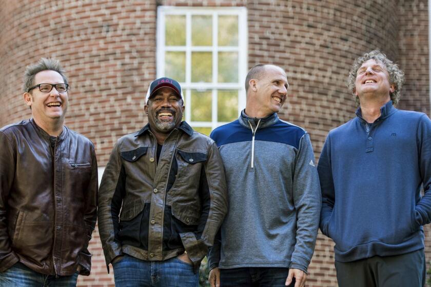 In this Nov. 16, 2018 photo, Dean Felber, from left, Darius Rucker, Jim Sonefeld, and Mark Bryan, of Hootie & the Blowfish, pose for a portrait at the University of South Carolina in Columbia, S.C. The band is returning with a tour and album 25 years after Cracked Rear View launched the South Carolina-based rock band. (Photo by Sean Rayford/Invision/AP)