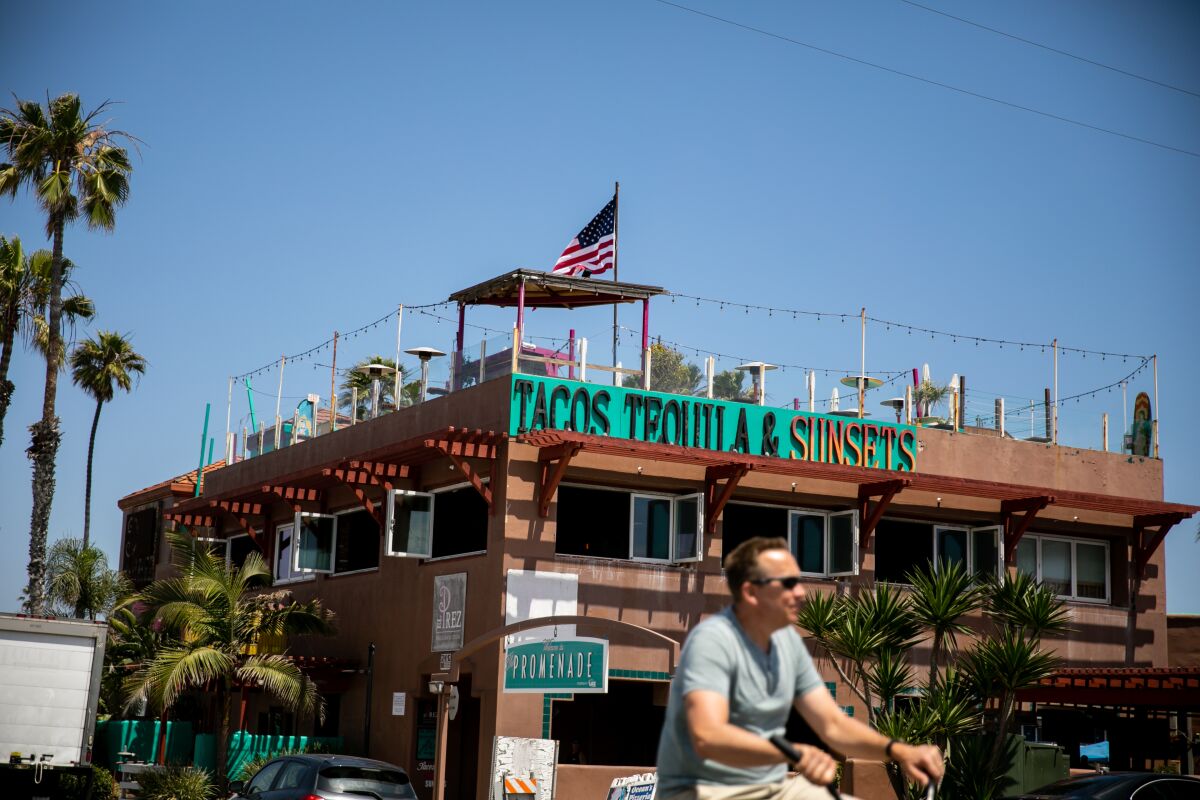 A cyclist rides a bike past El Prez in Pacific Beach ahead of Memorial Day Weekend on May 22, 2020 in San Diego, California. The bar and restaurant was shut down by the county on Friday after images circulated on social media showing a lack of social distancing at the establishment.