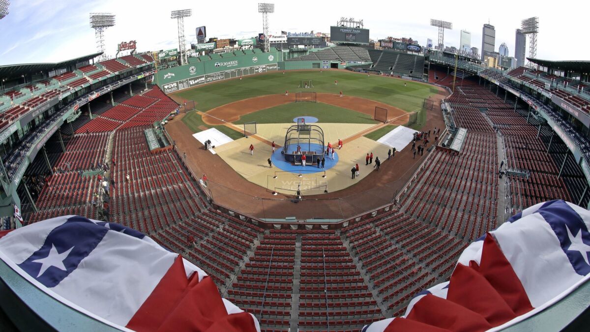 Bunting billows up in the wind at the upper deck of Boston's Fenway Park as Red Sox players work out in preparation for Game 1 of the World Series on Tuesday against the Dodgers.