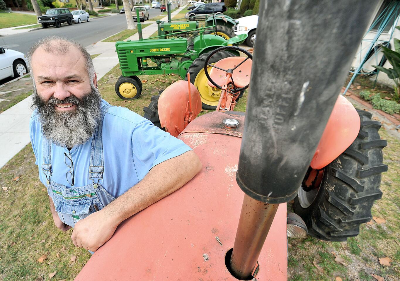 Burbank resident Dan Mustoe stands next to an Allis-Chalmers tractor that is one of three parked in his front yard on Mariposa Street for passersby to enjoy.