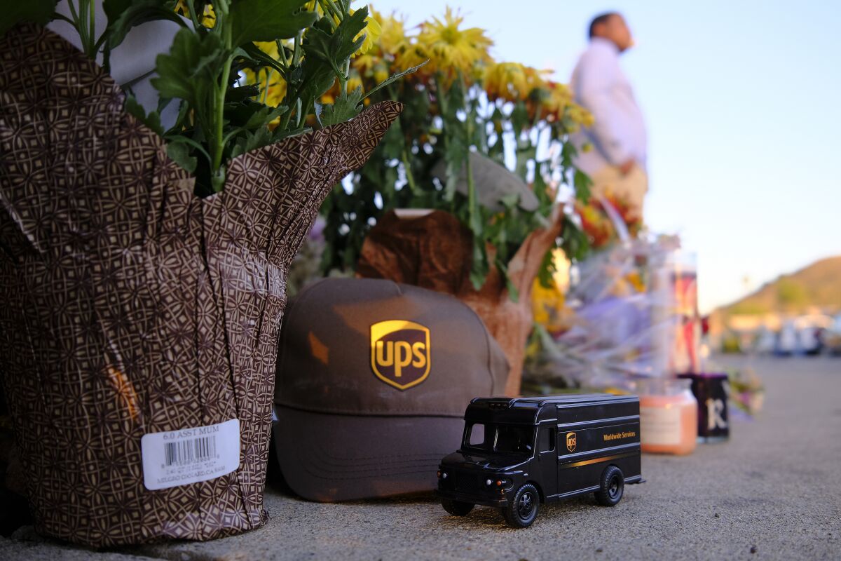 A toy UPS truck and a baseball hat are placed at a streetside memorial in Santee for Steve Krueger of Ocean Beach.