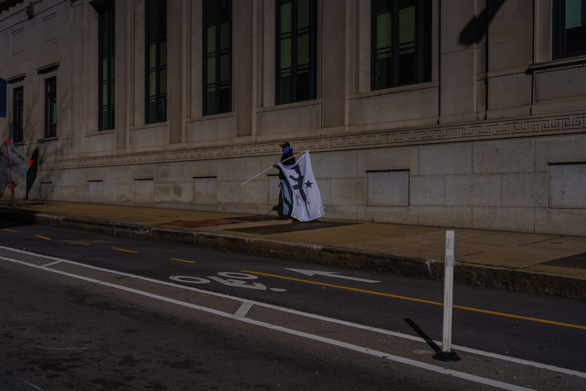 A person walks with a flag in Richmond, Va., on Monday.