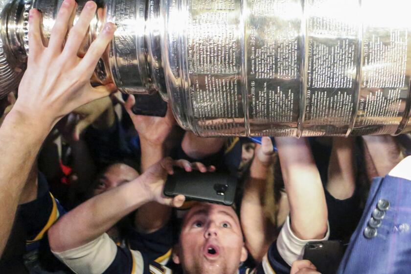 Fans reach out to touch the Stanley Cup after the St. Louis Blues NHL hockey team arrived at the airport in St. Louis early Thursday, June 13, 2019. The Blues defeated the Boston Bruins 4-1 in Game 7 of the Stanley Cup finals to win their first NHL championship Wednesday night in Boston. (Colter Peterson/St. Louis Post-Dispatch via AP)