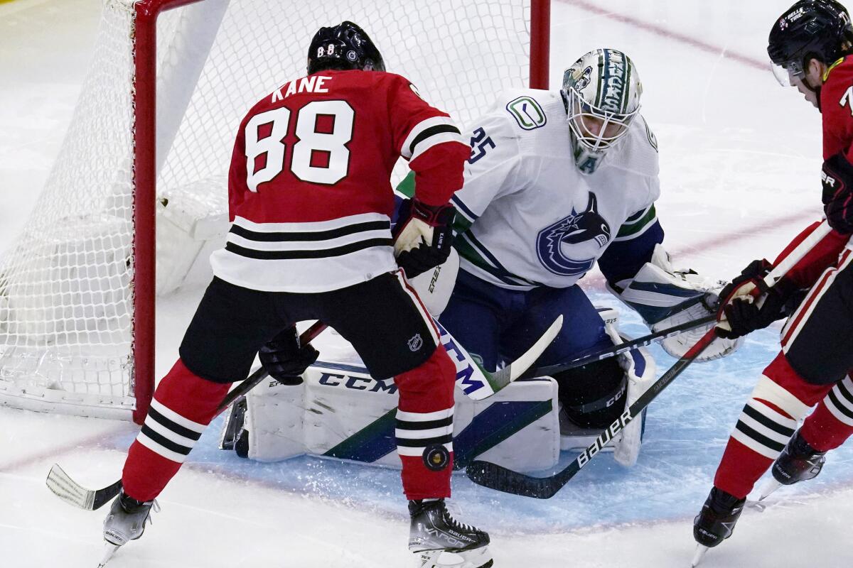 Vancouver Canucks goaltender Thatcher Demko (35) makes a save on a shot by Chicago Blackhawks right wing Patrick Kane, left, during the first period of an NHL hockey game in Chicago, Thursday, Oct. 21, 2021. (AP Photo/Nam Y. Huh)