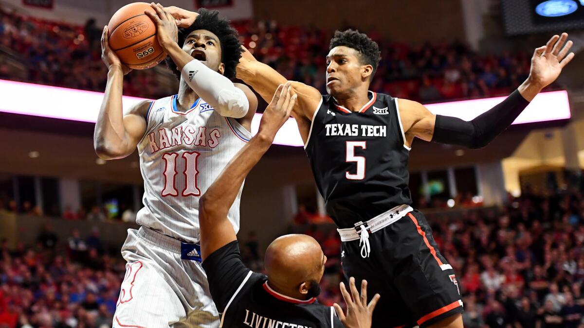 Kansas guard Josh Jackson tries to score against Texas Tech's Justin Gray (5) and Anthony Livingston during the first half Saturday.