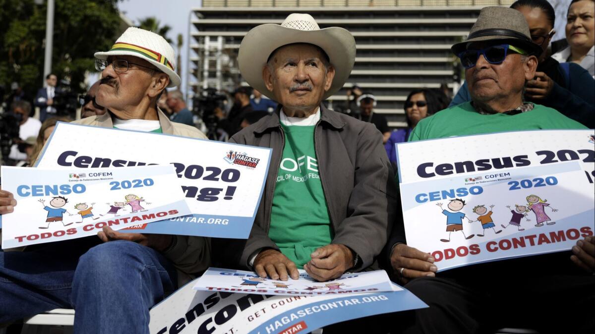 Members of the Council of Mexican Federations Isidoro Real, left, Cardona Bautista Araujo, and Manuel Lopez listen during a news conference and rally in Grand Park to call for a full and accurate count in the 2020 census for the city and county.
