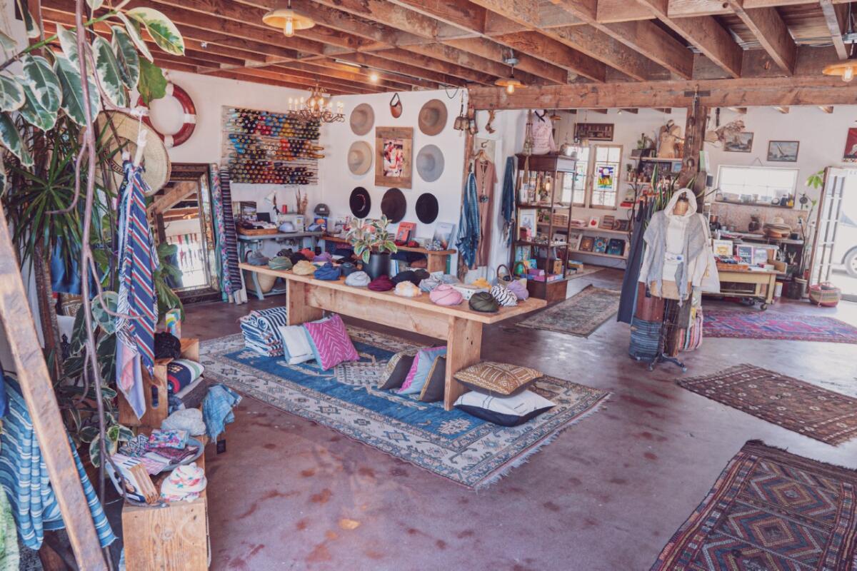 Hats, rugs, pillows and clothing in a shop. 