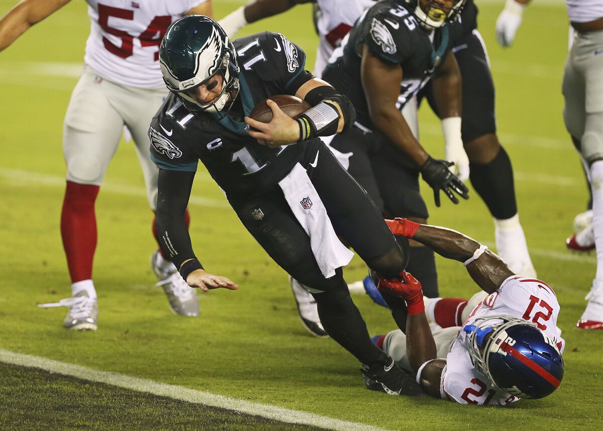 Philadelphia Eagles' Carson Wentz is tackled by New York Giants' Gabriel Peppers as he scores a rushing touchdown.