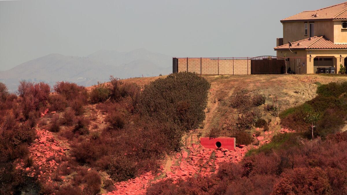 Fire retardant that was dropped by a firefighting jet to protect houses is seen over the canyon slope at the site of the Holy Fire in Lake Elsinore, California on August 12.