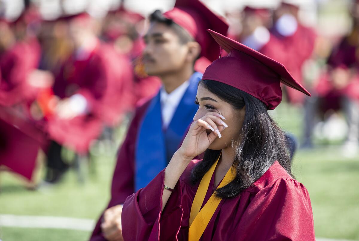 An Estancia High graduate wipes tears from her eyes during the school's commencement ceremony Thursday.