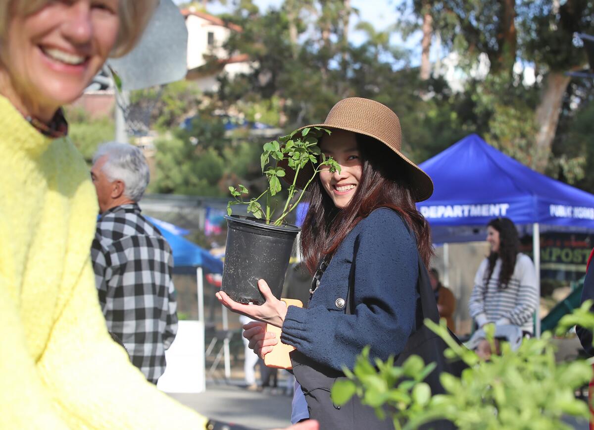 A guest is happy to get an elderberry sprout during the annual Arbor Day festival at Boat Canyon Park in Laguna Beach.