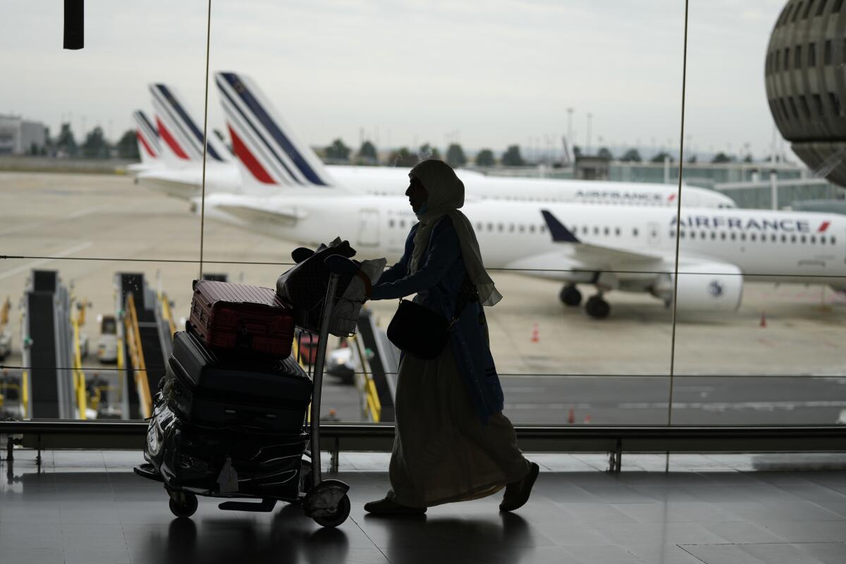 A traveler pulls her trolley Friday, Sept. 16, 2022 at Roissy Charles de Gaulle airport, north of Paris. Many domestic and some international flights were canceled in France Friday as air traffic controllers went on a national strike over pay and recruitment issues. French civil aviation authority DGAC warned that domestic traffic would be "severely disrupted" with many flights canceled and other experiencing long delays. Travelers have been advised to postpone their trip if possible. (AP Photo/Francois Mori)
