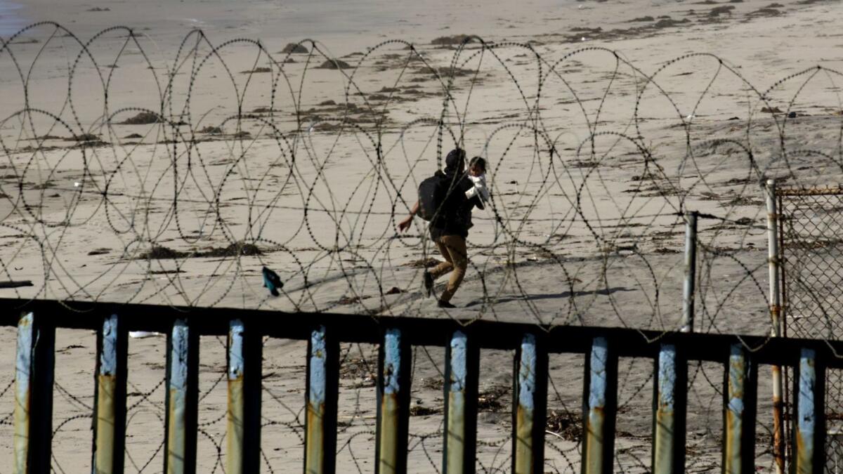 A 22-year-old Honduran man squeezed through the pillars in Tijuana on Wednesday carrying his child while Customs and Border Patrol was not on watch. They disappeared into the distance and did not appear to be captured, but this was not confirmed.