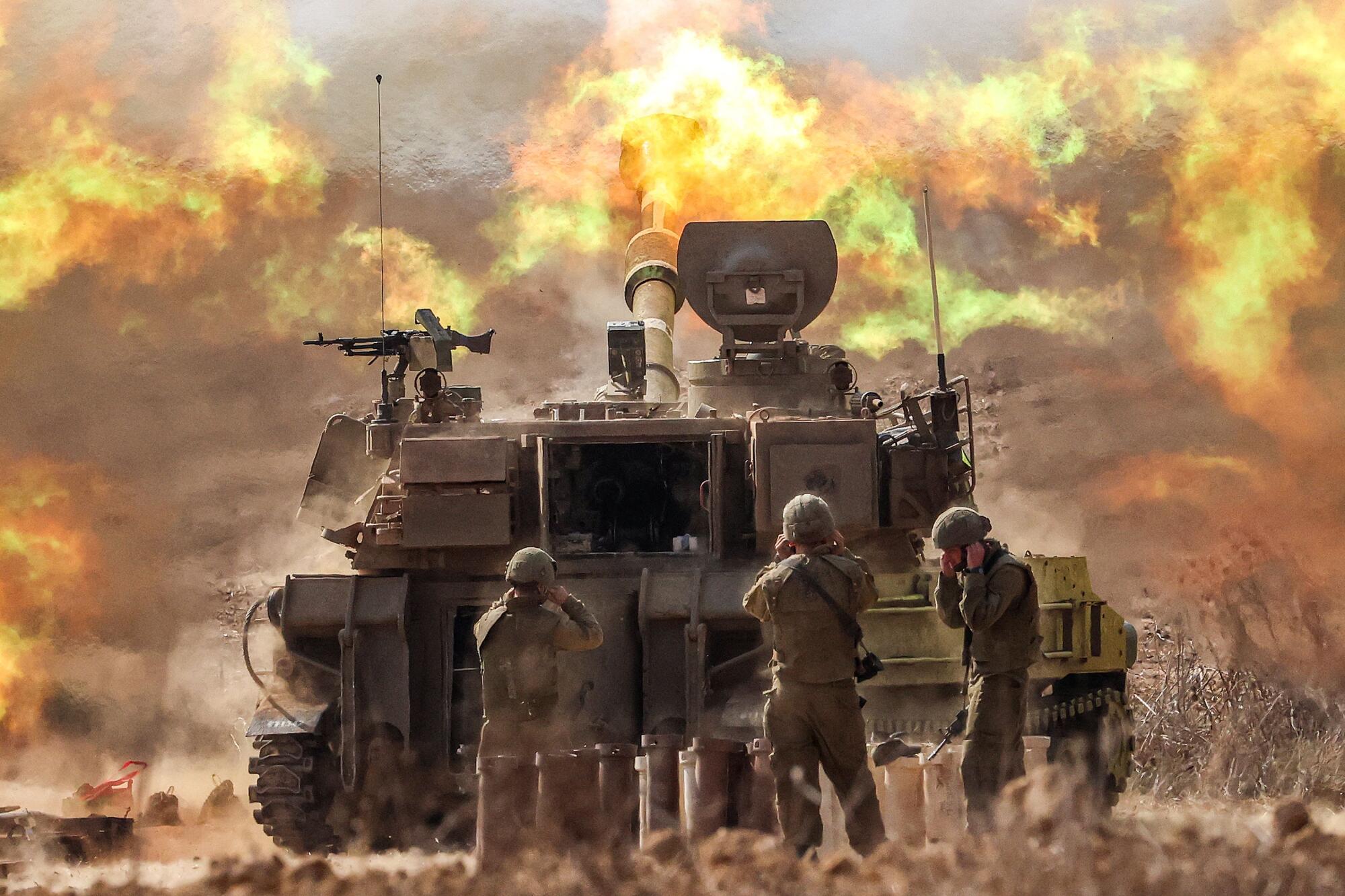 An Israeli army self-propelled howitzer fires rounds.