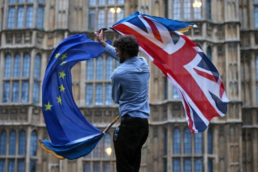 A man waves the British and European Union flags outside the Houses of Parliament in London on June 28, 2016.