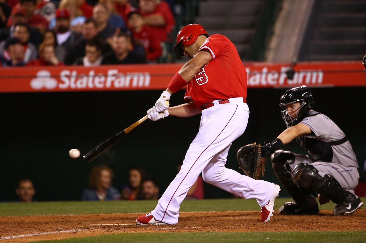 Albert Pujols hits a single in the eighth inning of the Angels' 5-2 victory over the Colorado Rockies on Tuesday at Angel Stadium.