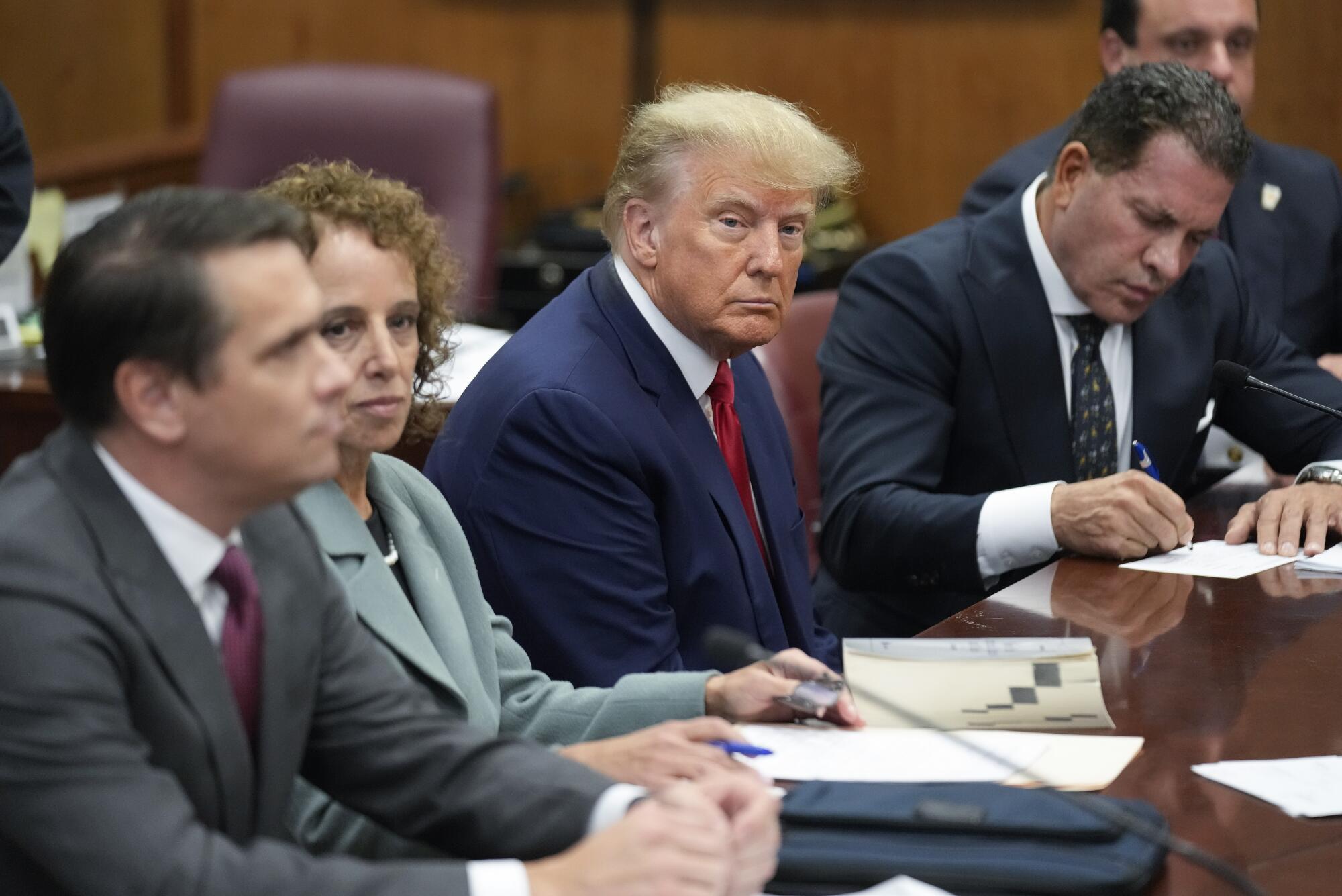 Former President Trump sits at the defense table with his defense team in a Manhattan courtroom.