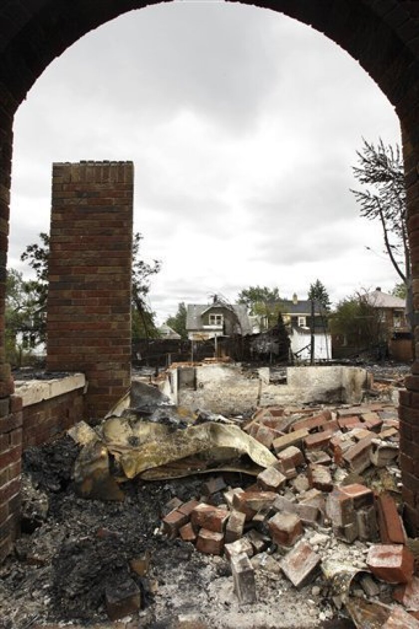 A burned home is seen through a remaining entryway of another home on Detroit's east side, Wednesday, Sept. 8, 2010. Wind-whipped flames swept through at least three Detroit neighborhoods, destroying dozens of homes, including many that were vacant, officials said. (AP Photo/Carlos Osorio)