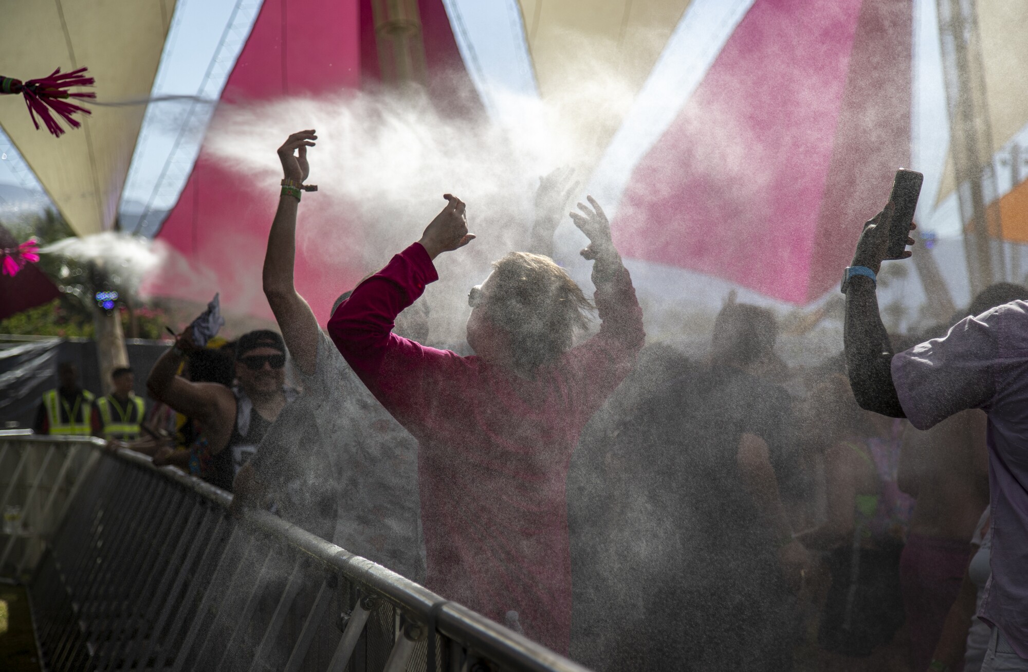 Las personas son rociadas con una neblina refrescante en el escenario Dolab del festival de Coachella.
