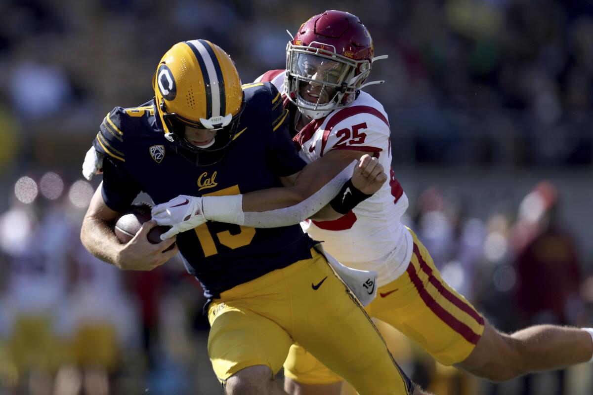 Cal quarterback Fernando Mendoza is tackled by USC linebacker Tackett Curtis during the first half Saturday.
