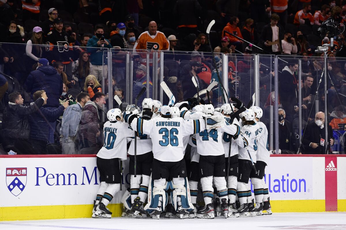 The San Jose Sharks celebrate an overtime victory after a goal scored by Tomas Hertl during an NHL hockey game against the Philadelphia Flyers, Saturday, Jan. 8, 2022, in Philadelphia. (AP Photo/Derik Hamilton)