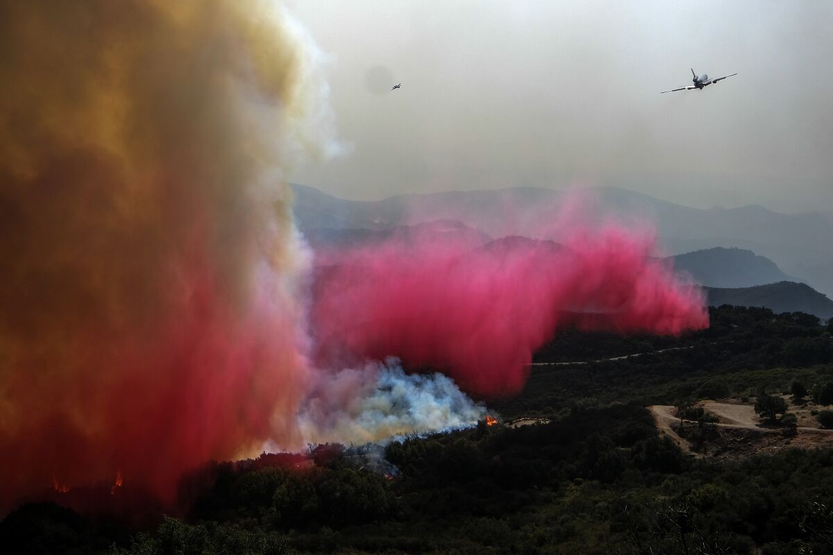 An air tanker drops retardant on a wildfire Wednesday, Oct. 13, 2021, in Goleta, Calif. (AP Photo/Ringo H.W. Chiu)