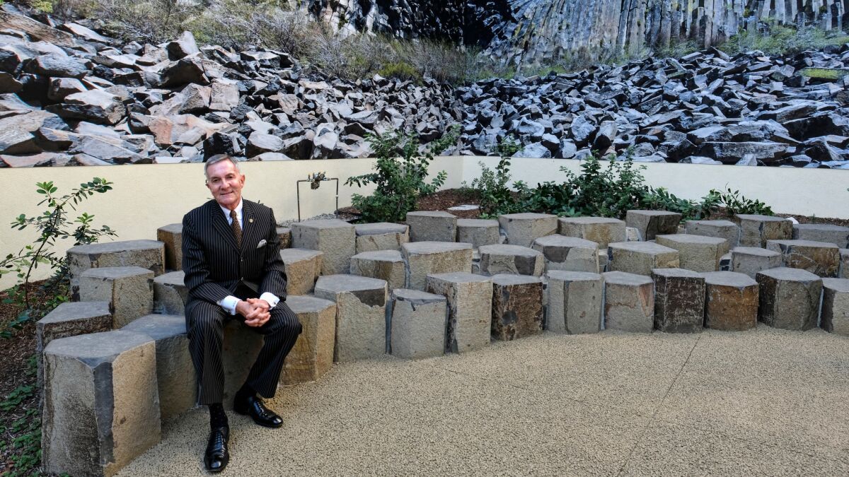 W. Richard West Jr. sits in a rocky seating area at the Autry Museum