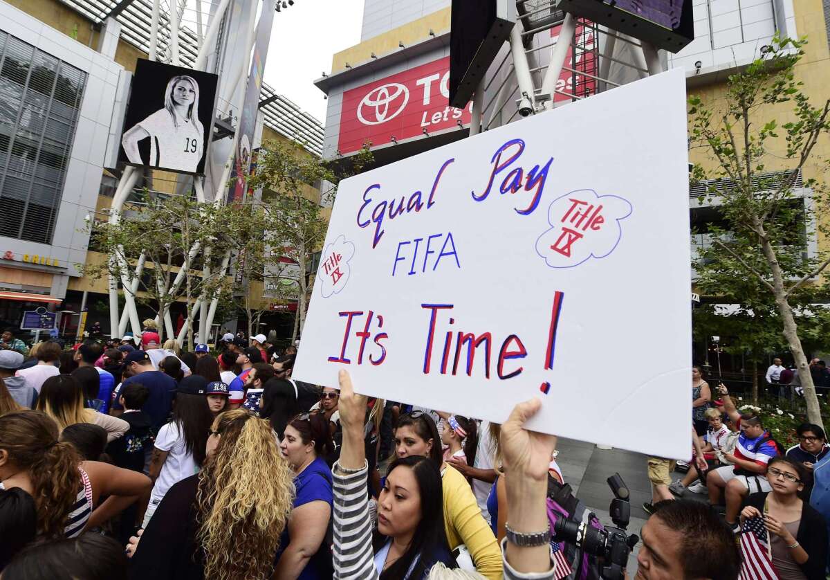 A soccer fan holds up a sign calling for equal pay for female athletes at the U.S. Women's World Cup football team's championship celebration rally at L.A. LIVE in downtown Los Angeles in July.