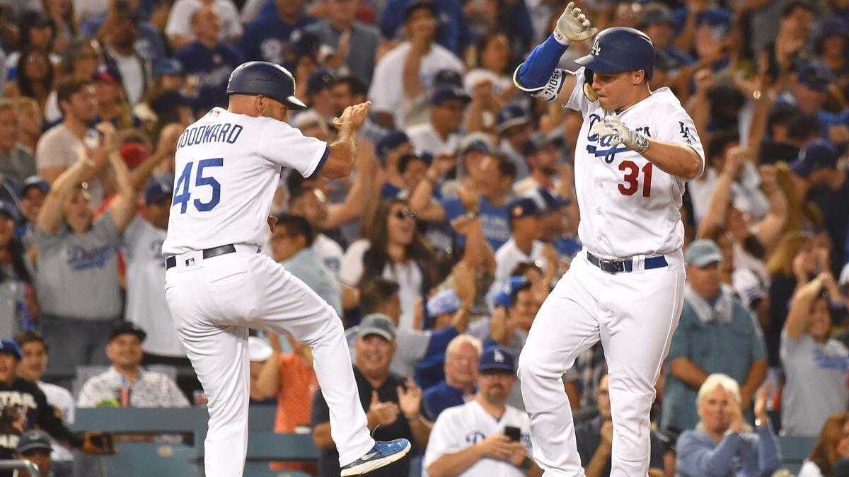 Dodgers' Joc Pederson (31) celebrates with third base coach Chris Woodward (45) as he heads home after hitting a three run home run in the sixth inning against the Angels on Tuesday.