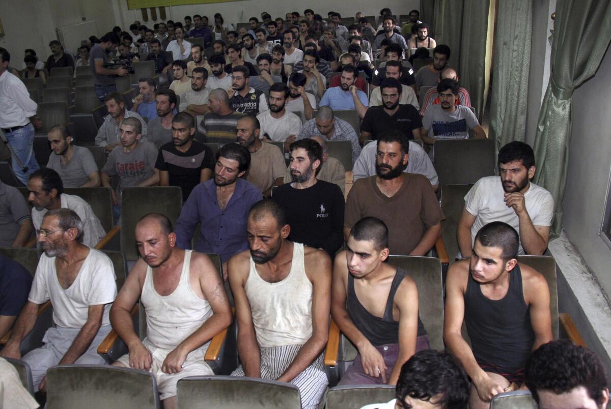 Syrians detained for taking part in antigovernment protests sit in a Damascus courtroom before their release last summer.