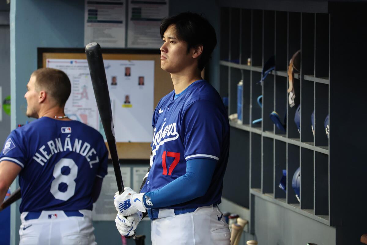 Dodgers star Shohei Ohtani stands in the dugout before a game against the Angels on Monday.
