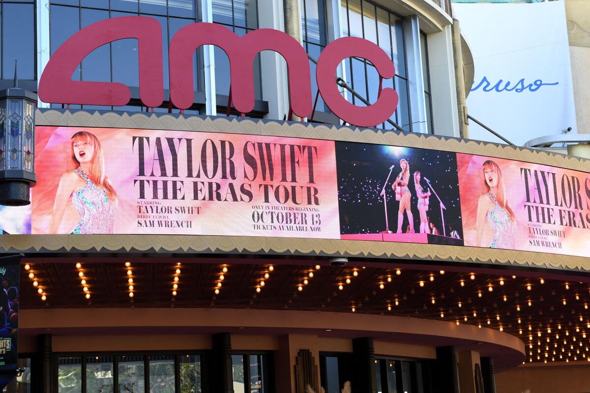An AMC marquee showing promotions for "Taylor Swift: The Eras Tour"
