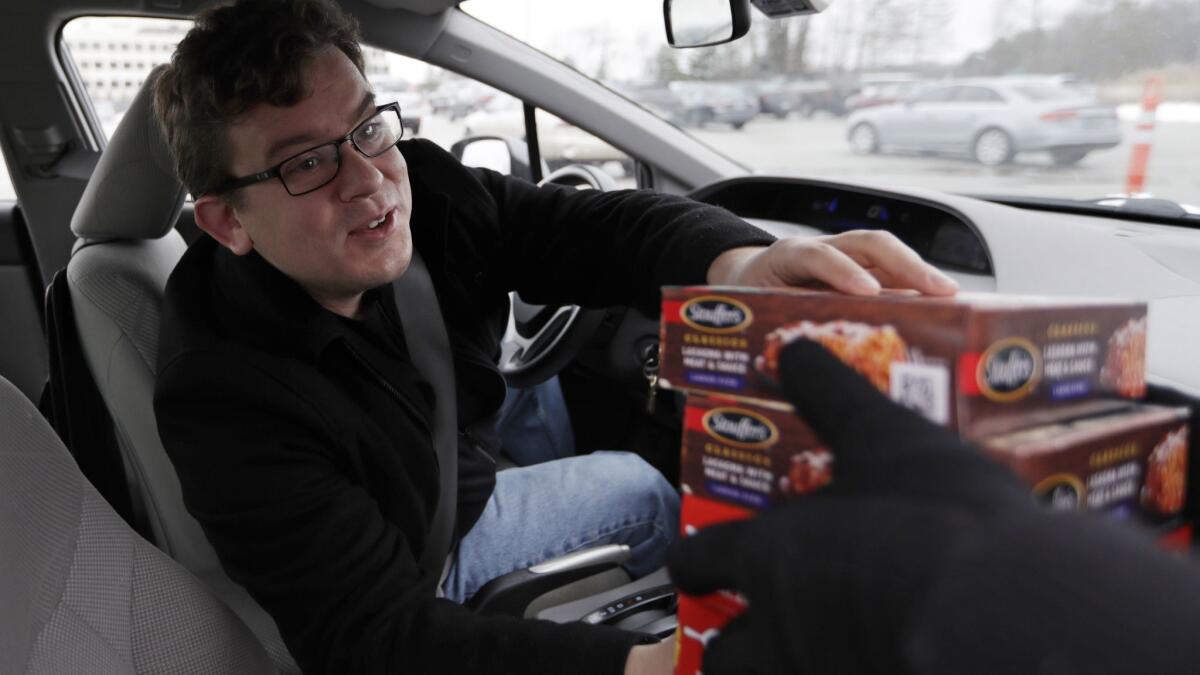 Tristan Hearn reaches for a donation on Wednesday in Solon, Ohio. Stouffers, headquartered in the city, was handing out the frozen meals to furloughed federal workers.
