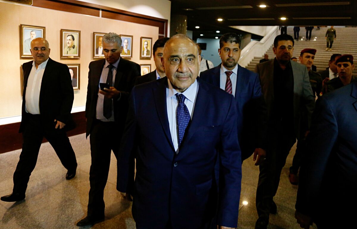 Iraq's new Prime Minister Adel Abdul-Mahdi, center, leaves the parliament building in Baghdad, Iraq, Tuesday, Oct. 2, 2018. Iraq's new president has tasked veteran Shiite politician Abdul-Mahdi with forming a new government nearly five months after national elections were held, state TV reported late Tuesday.