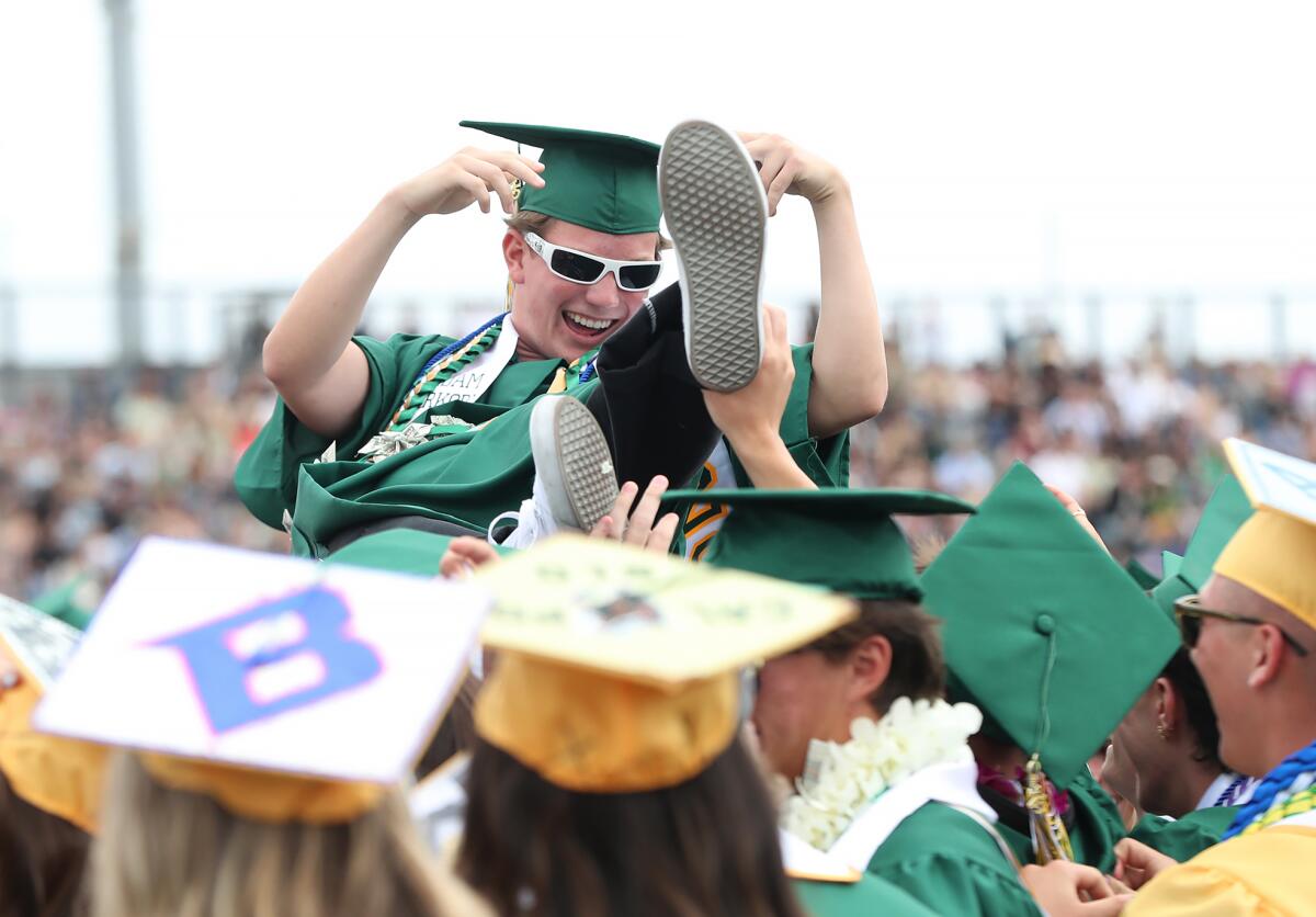 Graduate Adam Kirkorn crowd surfs during a dance circle at the 2025 Edison High commencement ceremony on Thursday.