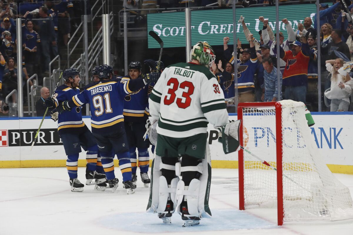 St. Louis Blues celebrate after a goal against Minnesota Wild goalie Cam Talbot during the second period in Game 6 of an NHL hockey Stanley Cup first-round playoff series Thursday, May 12, 2022, in St. Louis. (AP Photo/Michael Thomas)