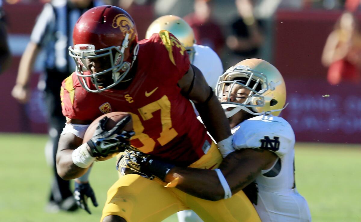 USC running back Javorius Allen is brought down by Notre Dame safety Elijah Shumate during the second quarter of the Trojans' 49-14 win over Notre Dame on Nov. 29 at the Coliseum.