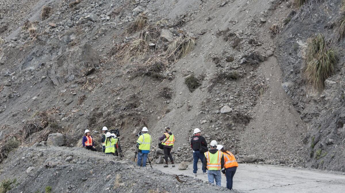 Caltrans officials and media members gather on Highway 1 where a landslide cut off the road north of Ragged Point.