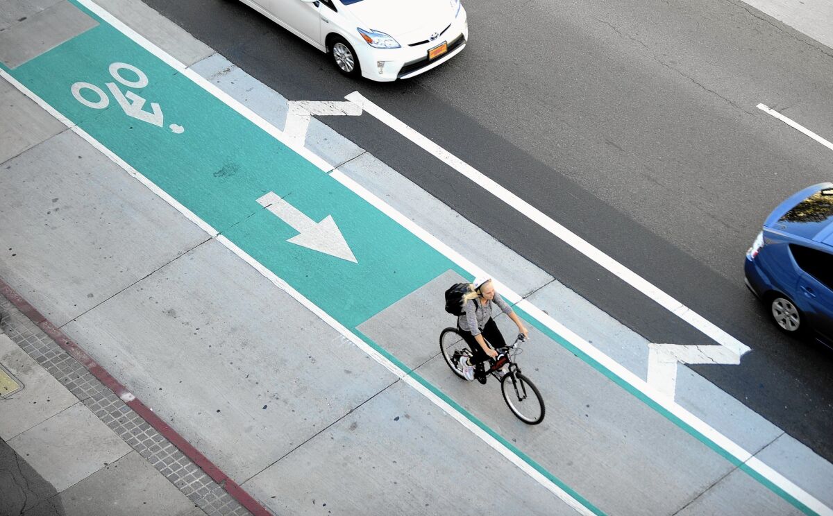 A cyclist uses a bike lane in downtown Los Angeles. Mobility Plan 2035, a sweeping transportation policy approved by the City Council, seeks to shift the city's emphasis away from the automobile.